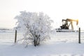 Pump jack in the sunrise light and the bush in snow in the oilfield Royalty Free Stock Photo