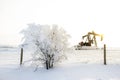 Pump jack in the sunrise light and the bush in snow in the oilfield Royalty Free Stock Photo