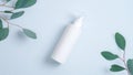 Pump plastic bottle for intimate gel dispenser or liquid soap on blue background with green eucalyptus leaves. Intimate hygiene, Royalty Free Stock Photo