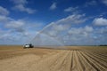 Pump truck irrigating fields near Homestead, Florida creating rainbow in spray.