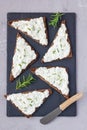 Pumpernickel bread with feta, cream cheese, rosemary, lemon and garlic dip, on a slate board, top view, vertical Royalty Free Stock Photo