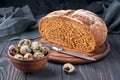 Pumpernickel - bread made with a combination of rye flour and whole rye grains. Quail eggs in a clay bowl, bread knife. Fresh Royalty Free Stock Photo