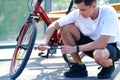 Pumping air into an empty bicycle wheel. A man shakes a bicycle wheel in a park. A person inflates a bicycle wheel with a pump Royalty Free Stock Photo