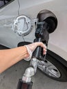 Pumping gas into car wearing latex gloves for protection. Royalty Free Stock Photo
