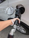 Pumping gas into car wearing latex gloves for protection.