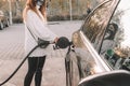 Pumping gas fuel car at oil station. Woman hand refuel petrol nozzle tank. Refueling transportation and Automotive industry Royalty Free Stock Photo