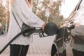 Pumping gas fuel car at oil station. Woman hand refuel petrol nozzle tank. Refueling transportation and Automotive industry Royalty Free Stock Photo