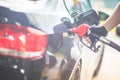 Pumping gas at gas pump. Closeup of man pumping gasoline fuel in car at gas station wearing racing gloves. Faded effect. Royalty Free Stock Photo