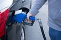 Pumping gas at gas pump. Closeup of man pumping gasoline fuel in Royalty Free Stock Photo