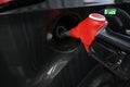 Pumping gas into gas-guzzler. Hand and black refueling gun close-up.