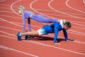 Pumping up muscles. athletic man and woman in stand plank. male and female coach on stadium arena. healthy lifestyle