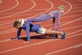 pumping up muscles. athletic man and woman in stand plank. male and female coach on stadium arena. healthy lifestyle