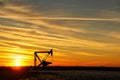 Pumpjack in the oil field at sunset Royalty Free Stock Photo