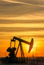 Pumpjack and transmission towers at sunset symbolizing energy transition