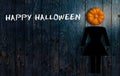 Pumpkin as a head of a person on wooden background and the message `Happy Halloween`