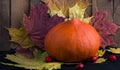 Pumpkin on Autumn background with colored leaves on wooden surface Royalty Free Stock Photo