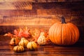 Pumpkin and Autumn leaves over old wooden background Royalty Free Stock Photo