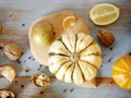 Pumpkin bright yellow with stripes on a cutting board, on a wooden table against the background of seasonal vegetables Royalty Free Stock Photo