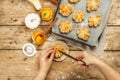 Pumpkin buns or biscuits, traditional fall baked goods. Female hands hold cookies