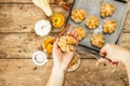 Pumpkin buns or biscuits, traditional fall baked goods. Female hands hold cookies