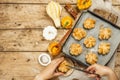 Pumpkin buns or biscuits, traditional fall baked goods. Female hands hold cookies