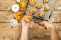 Pumpkin buns or biscuits, traditional fall baked goods. Female hands hold cookies