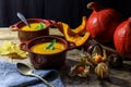 Pumpkin or butternut squash soup in bowls with autumn leaf, gooseberry Royalty Free Stock Photo