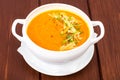 Pumpkin carrot cream soup with parmesan and green shoots of watercress Royalty Free Stock Photo