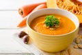 Pumpkin and carrot cream soup with pumpkin seeds and parsley in bowl on white wooden background. Royalty Free Stock Photo