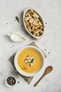 Pumpkin and carrot soup with cream and spinach with crackers on a white background