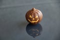 A pumpkin with a carved jack-o\'-lantern face creates a cheerful reflection on a glossy surface Royalty Free Stock Photo