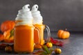 Pumpkin cocktail with whipped cream in glass mugs. Pumpkin autumn drink for Halloween or Thanksgiving