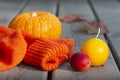Pumpkin, crab apple, autumn colorful maple leaves, yellow candle and orange wool sweater on a sunny day