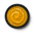 Pumpkin cream soup in black bowl isolated on white background, top view Royalty Free Stock Photo