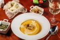 Pumpkin cream soup with croutons, baked chickpeas, sesame, parsley on a brown wooden background. Baked chickpeas with spices.