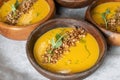 Pumpkin cream soup decorated with crunchy buckwheat in beautiful wooden plates.