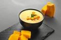 pumpkin cream soup mashed potatoes on a gray background. Vegan curried pumpkin lentil soup puree in a bowl. Space for