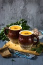 Pumpkin cream soup in mugs on gray blue background