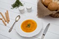 Pumpkin cream soup puree on a light wooden table in a white plate. top view Royalty Free Stock Photo