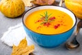 Pumpkin cream soup with rosemary and paprika in blue bowl. Halloween Thanksgiving Autumn food concept Royalty Free Stock Photo