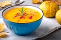 Pumpkin cream soup with rosemary and paprika in blue bowl. Halloween Thanksgiving Autumn food concept Royalty Free Stock Photo