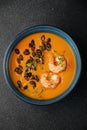 Pumpkin cream soup with seeds and shrimps on dark concrete background and microgreen top view Royalty Free Stock Photo