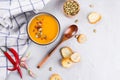 Pumpkin cream soup with seeds, toast and seasoning in a ceramic bowl on a table. Royalty Free Stock Photo