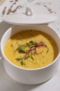 Pumpkin cream soup served with herbs in ceramic pot with lid Royalty Free Stock Photo