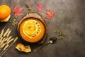 Pumpkin cream soup with sour cream and seeds on a dark grunge background. Warming autumn and winter soup. Overhead view, copy
