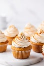 Pumpkin cupcakes on a white table topped with cream cheese frosting and dusted with cinnamon, generative AI