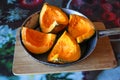 Pumpkin cut into quarters in a pan