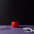 Pumpkin decoration for Helloween and hand bones on purple black background with copy space