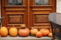 Pumpkin decoration at wooden doors outdoors. Stylish autumn decor of exterior building