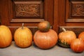 Pumpkin decoration at wooden doors outdoors. Stylish autumn decor of exterior building